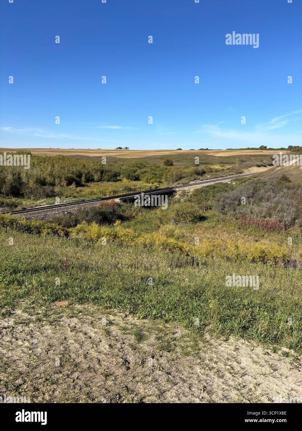 ''A lone rail bridge crosses a small creek on the vast prairie, leading the way to open country under a perfect blue sky.'' - Smartphone Captured Stock Image ''A lone rail bridge crosses a small creek on the vast prairie, leading the way to open country under a perfect blue sky.'' - Smartphone Captured Stock Image