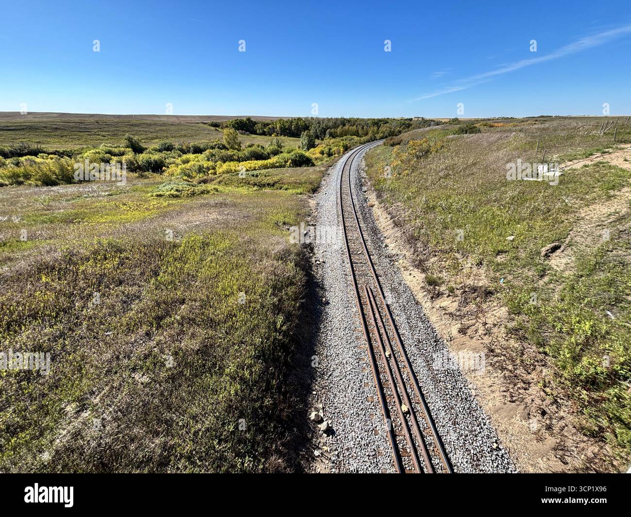 ''The long road ahead. A single set of train tracks disappears into the distance of the prairie.'' - Smartphone Captured Stock Image
