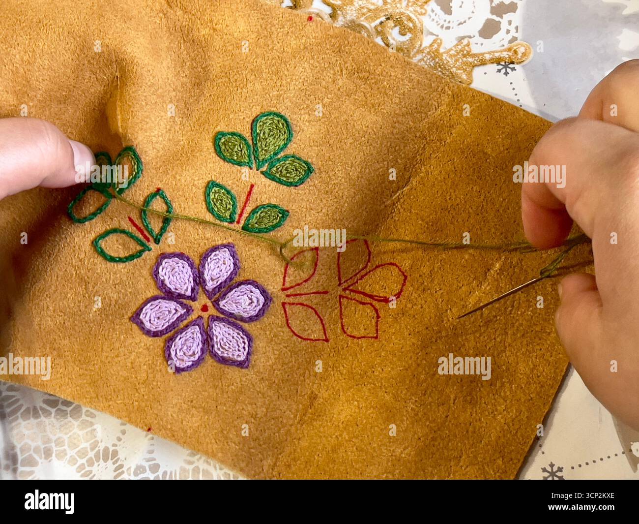 Indigenous hands doing embroidery on moose-hide - Smartphone Captured Stock Image