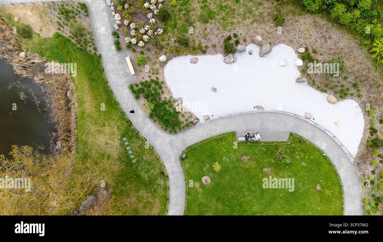 Aerial view of a landscaped park with pathways, greenery, and a pond ...