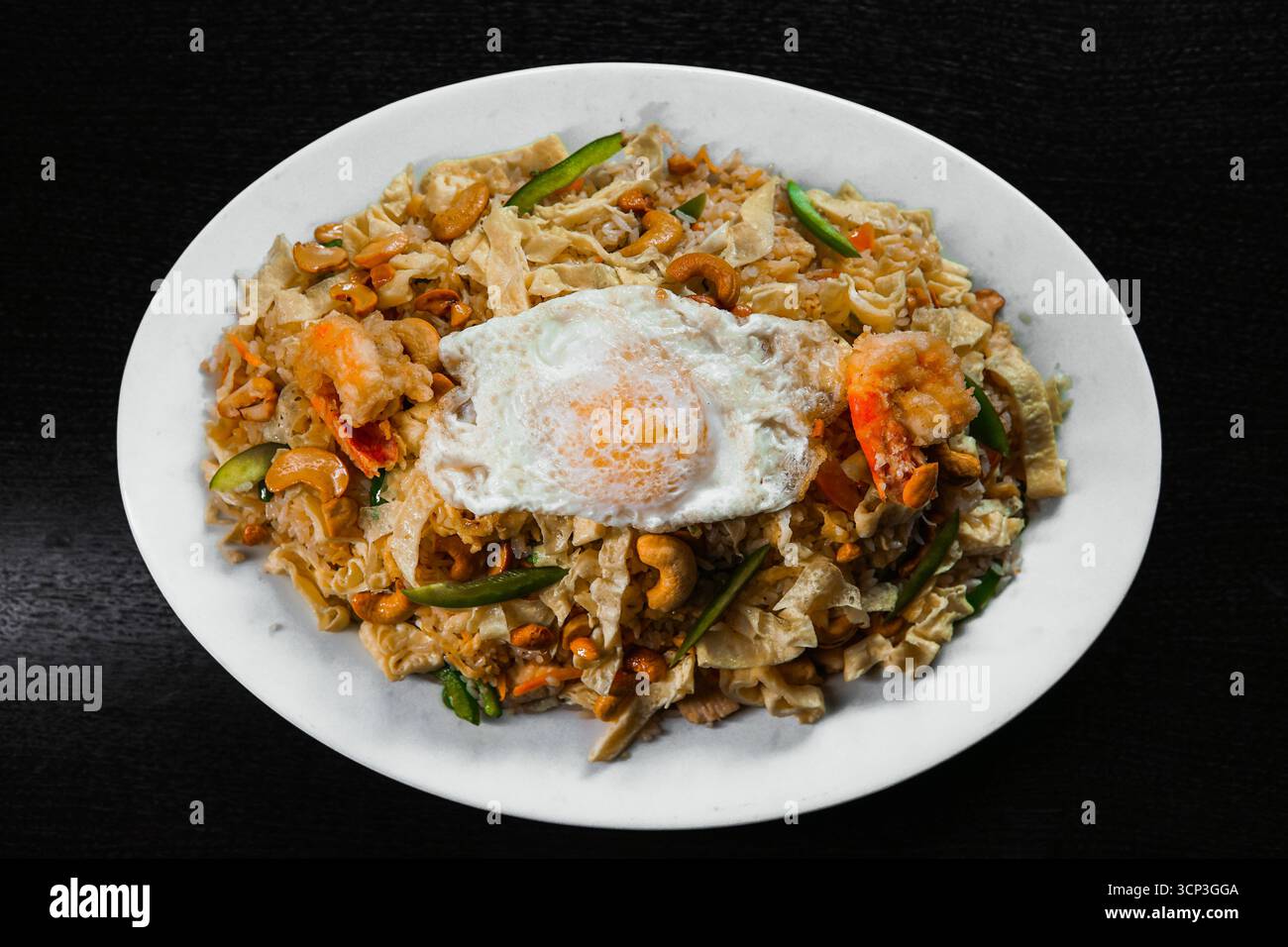 Special Mixed Fried Rice with Prawns, Chicken, Cashews, and a Sunny-Side Up Egg Stock Photo