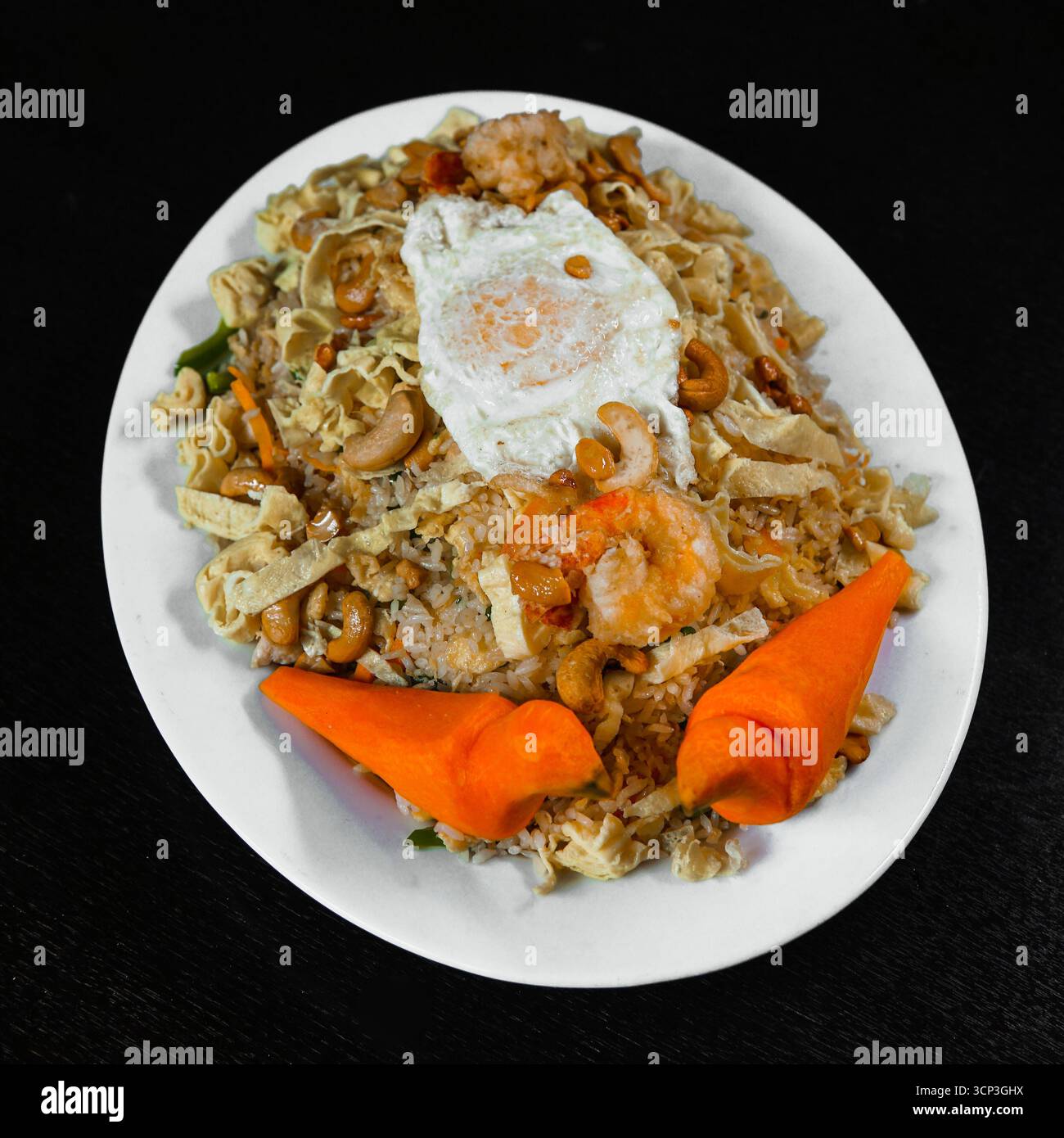 Special Mixed Fried Rice with Prawns, Chicken, Cashews, and a Sunny-Side Up Egg Stock Photo