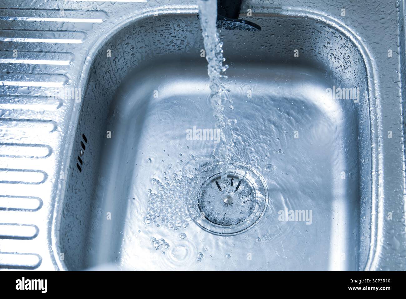 Water flowing from tap into sink, closeup Stock Photo - Alamy