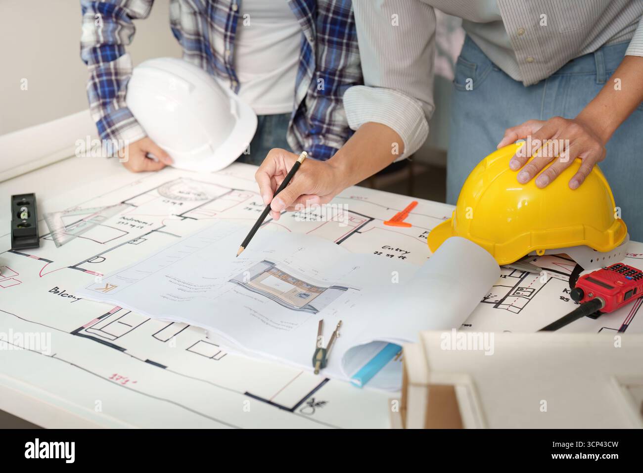 Engineers reviewing construction plans in modern workspace Stock Photo