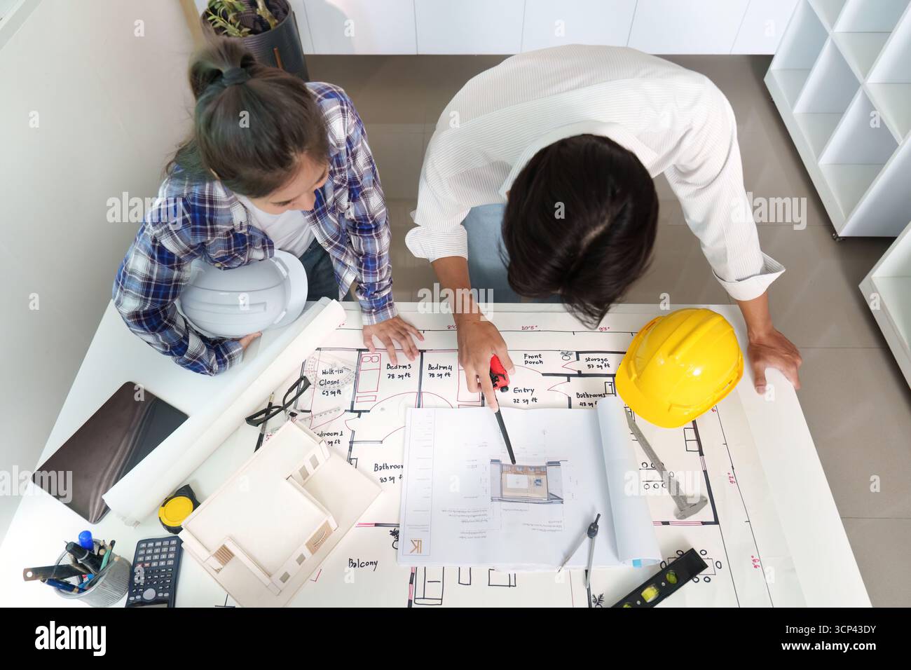 Engineer collaborating on architectural plans with a colleague Stock Photo