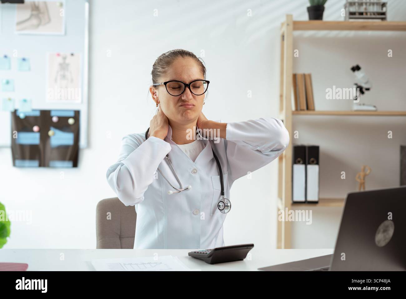 female doctor having a health problem suffering neckache problem caused hardworking. Healthcare worker overworked. Copy space Stock Photo