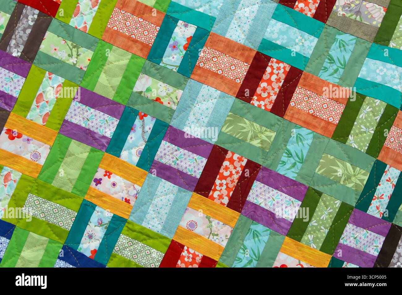 A patchwork quilt with many different colored squares. Abstract background Stock Photo