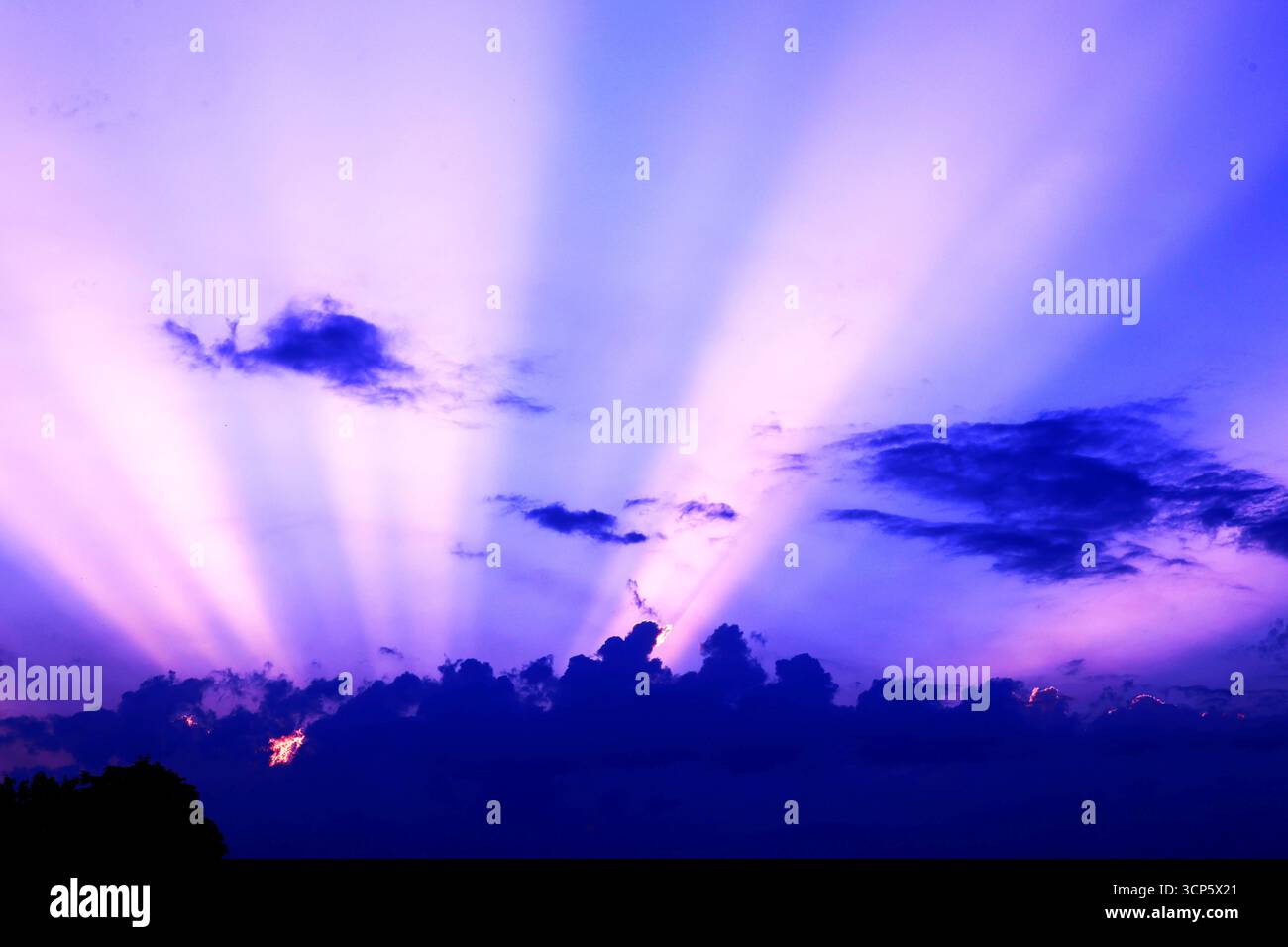 Majestic Crepuscular Rays Bursting Through Clouds Stock Photo