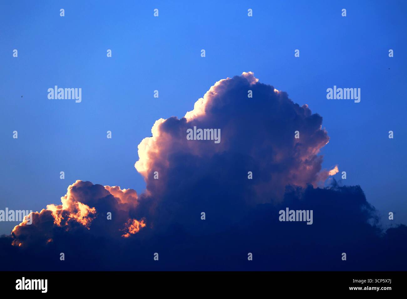 Sunset Cloud Formation with Illuminated Edges Stock Photo