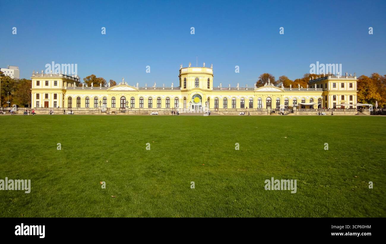 Baroque Orangerie palace in Karlsaue Park, Kassel, Germany, with green lawn and blue sky on a sunny autumn day. Stock Photo