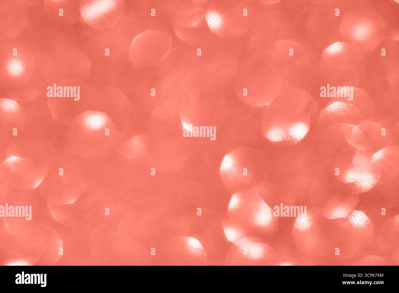 Coral pink bokeh background with circular light patterns and soft abstract texture. Stock Photo