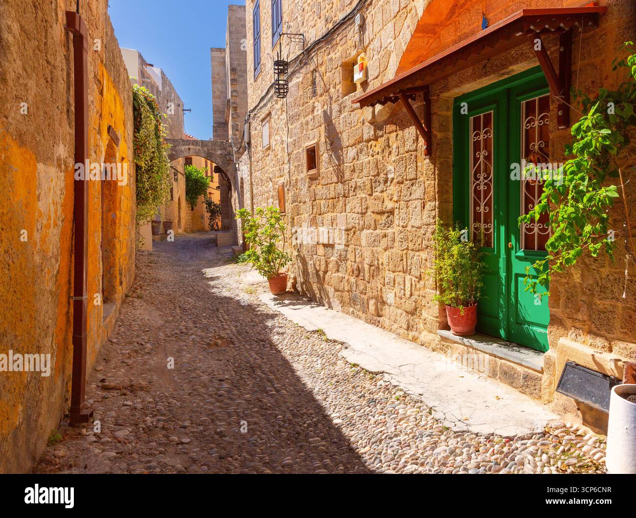 Cobblestone alley with stone buildings in the old town of Rhodes Greece ...