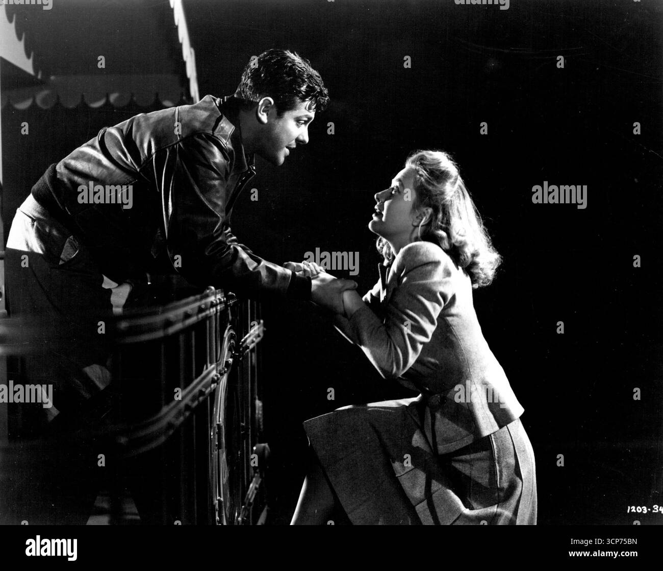 'Saboteur': Barry Kane (Robert Cummings) and Patricia Martin (Priscilla Lane) hop a ride on a circus bus after fighting their way through a desert sand storm. January 01, 1942. Stock Photo