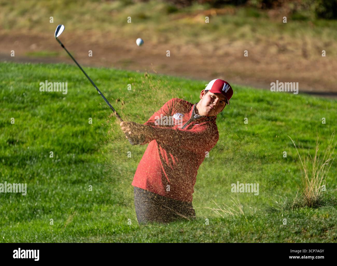 Washington State's Dylan Burcham hits out of a bunker during an NCAA ...