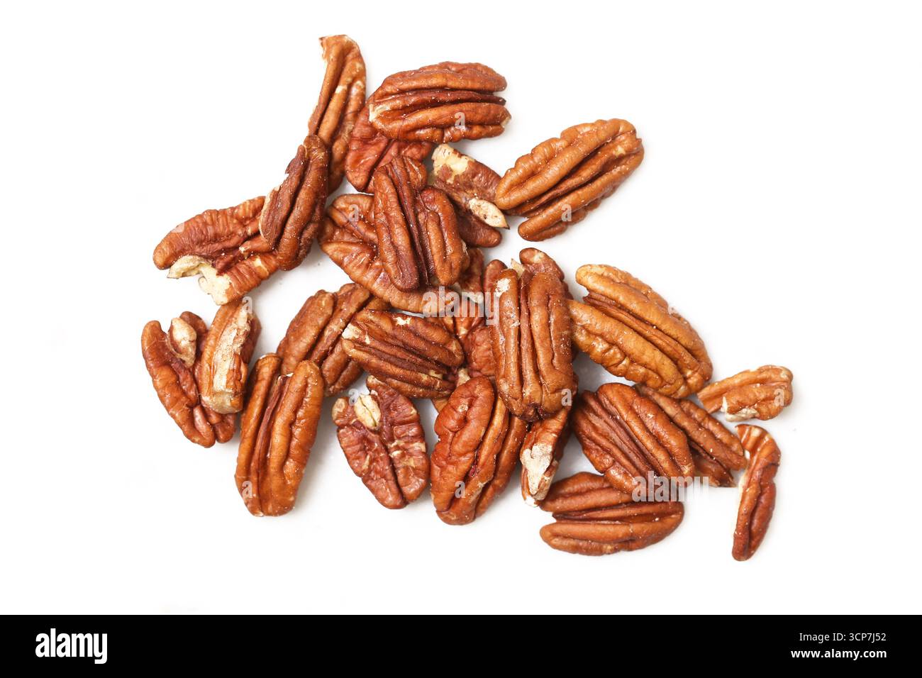 Pecan nuts isolated on white. Brown organic kernels closeup. Natural healthy snack food. Protein rich vegan ingredient. Rustic agriculture harvest. Stock Photo