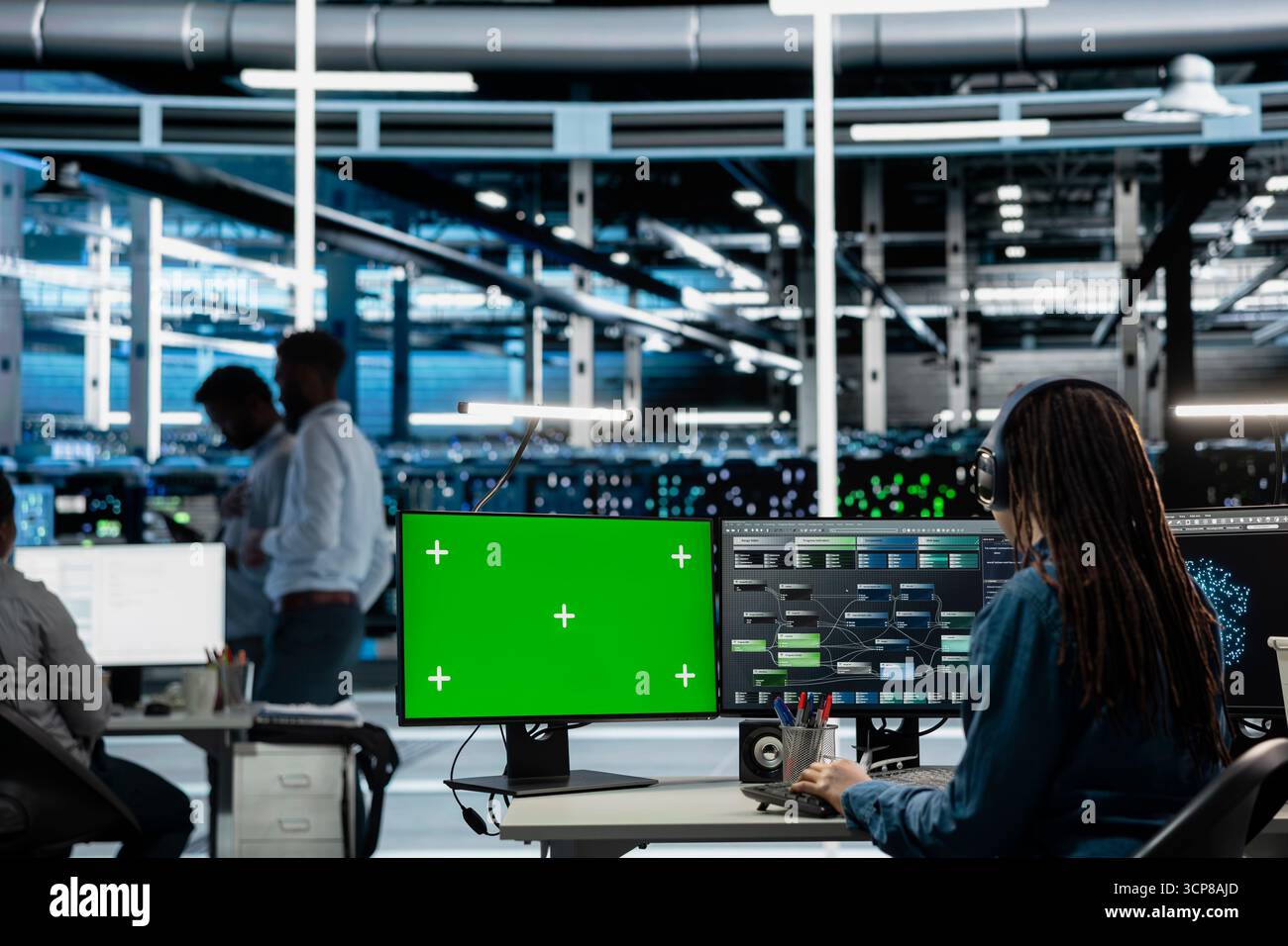 Engineer in server farm using green screen PC to repair equipment storing datasets. IT professional using mockup computer to do debugging on rigs doing computational operations Stock Photo
