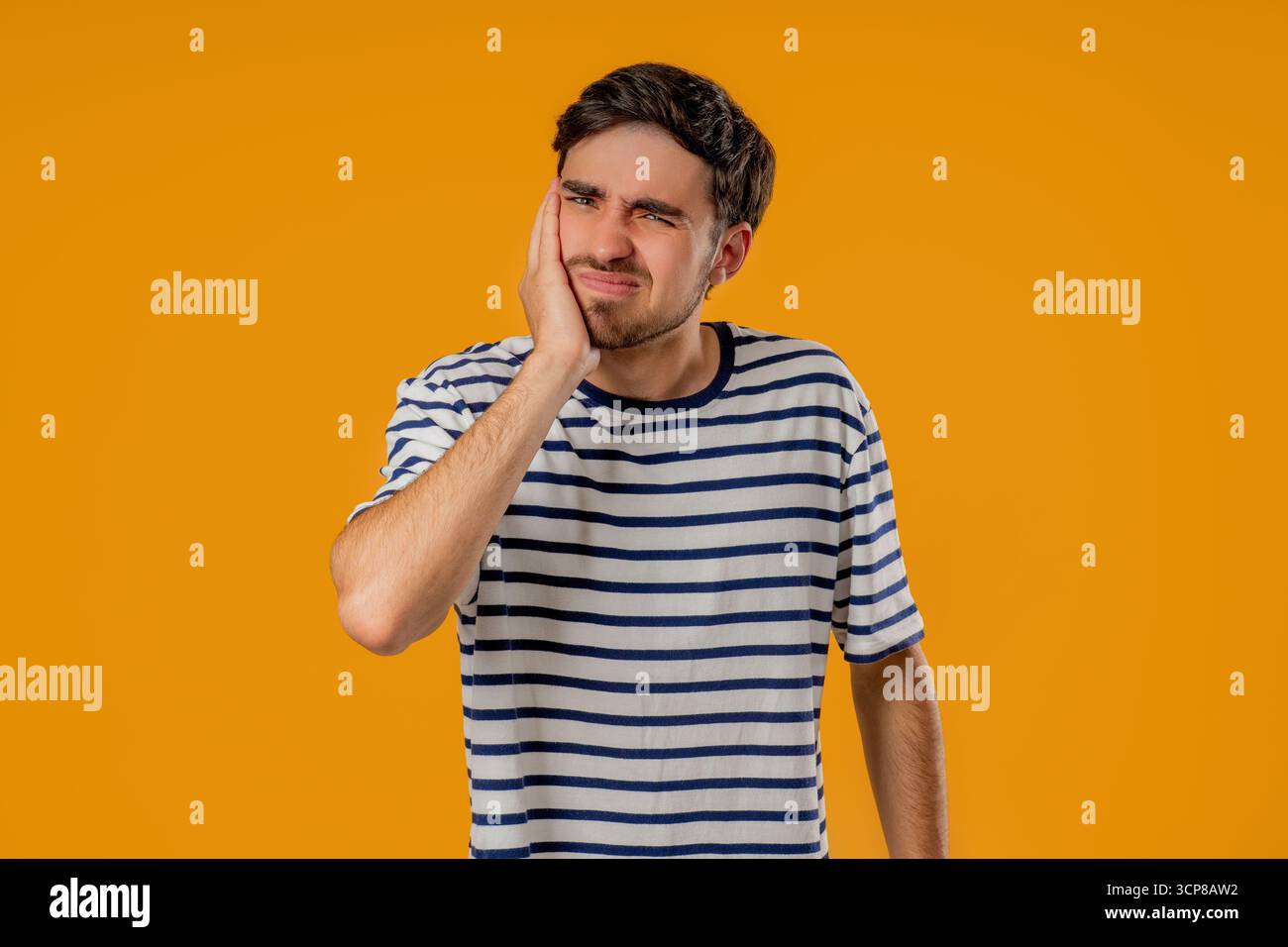 Young Man Touching Cheek With Painful Expression, Reacting To Sudden ...