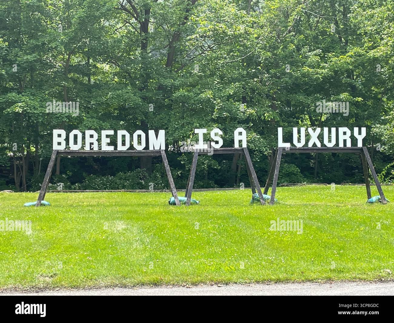 Artwork in a park that says boredom is a luxury, America, USA United States, New York State - Smartphone Captured Stock Image