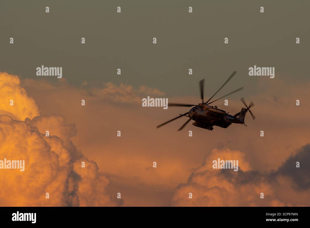 San Diego, California, USA - September 18, 2025: U.S. Marine Corps Sikorsky CH-53E Super Stallion banks over sunset clouds during an evening flight. Stock Photo