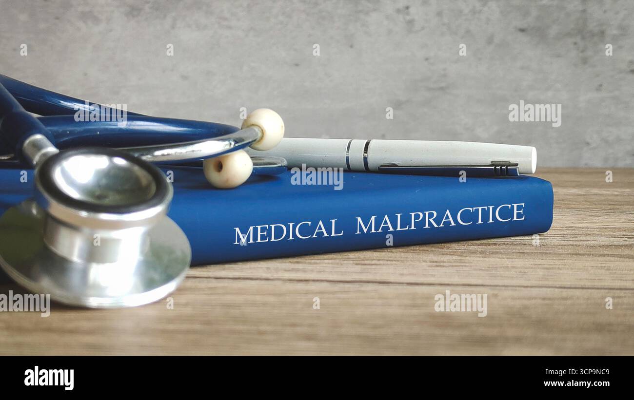 Stethoscope and a pen on a book titled 'MEDICAL MALPRACTICE,' representing legal issues in healthcare. Stock Photo
