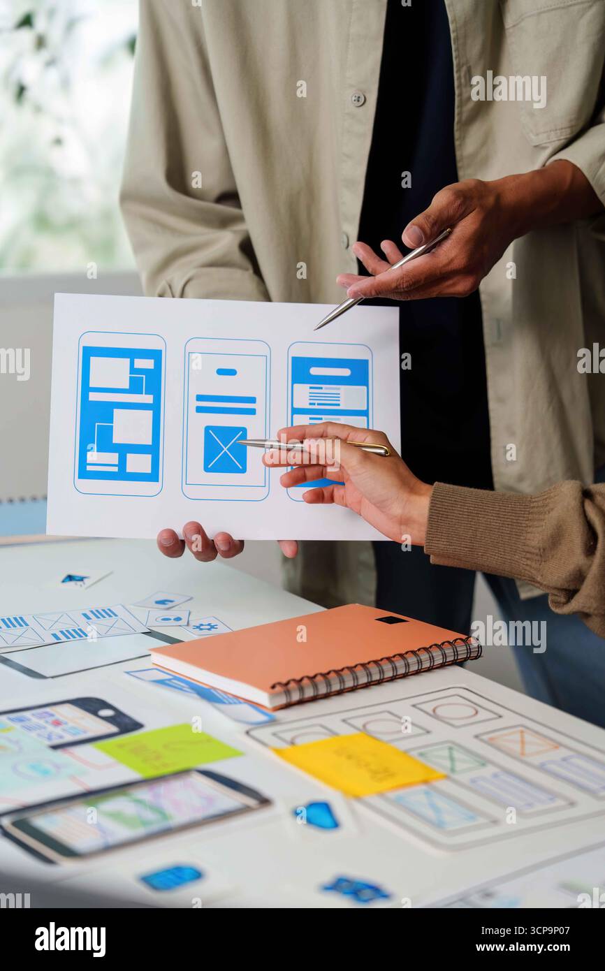 Collaborative UI UX Design. Team analyzing mobile app wireframes and ...