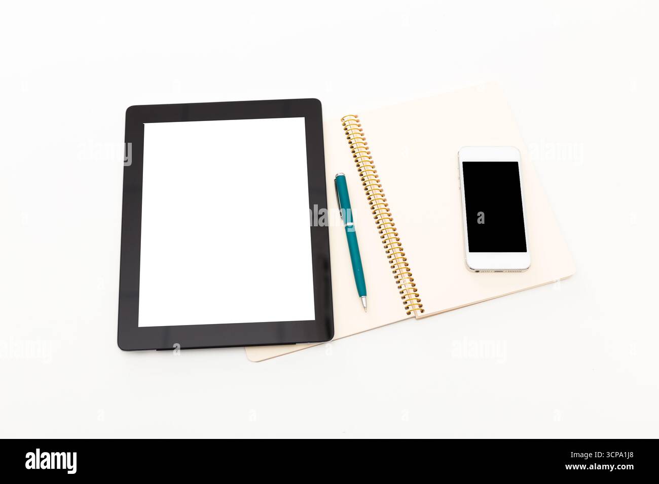Workspace setup with tablet, notebook, pen, and smartphone displayed on white background Stock Photo