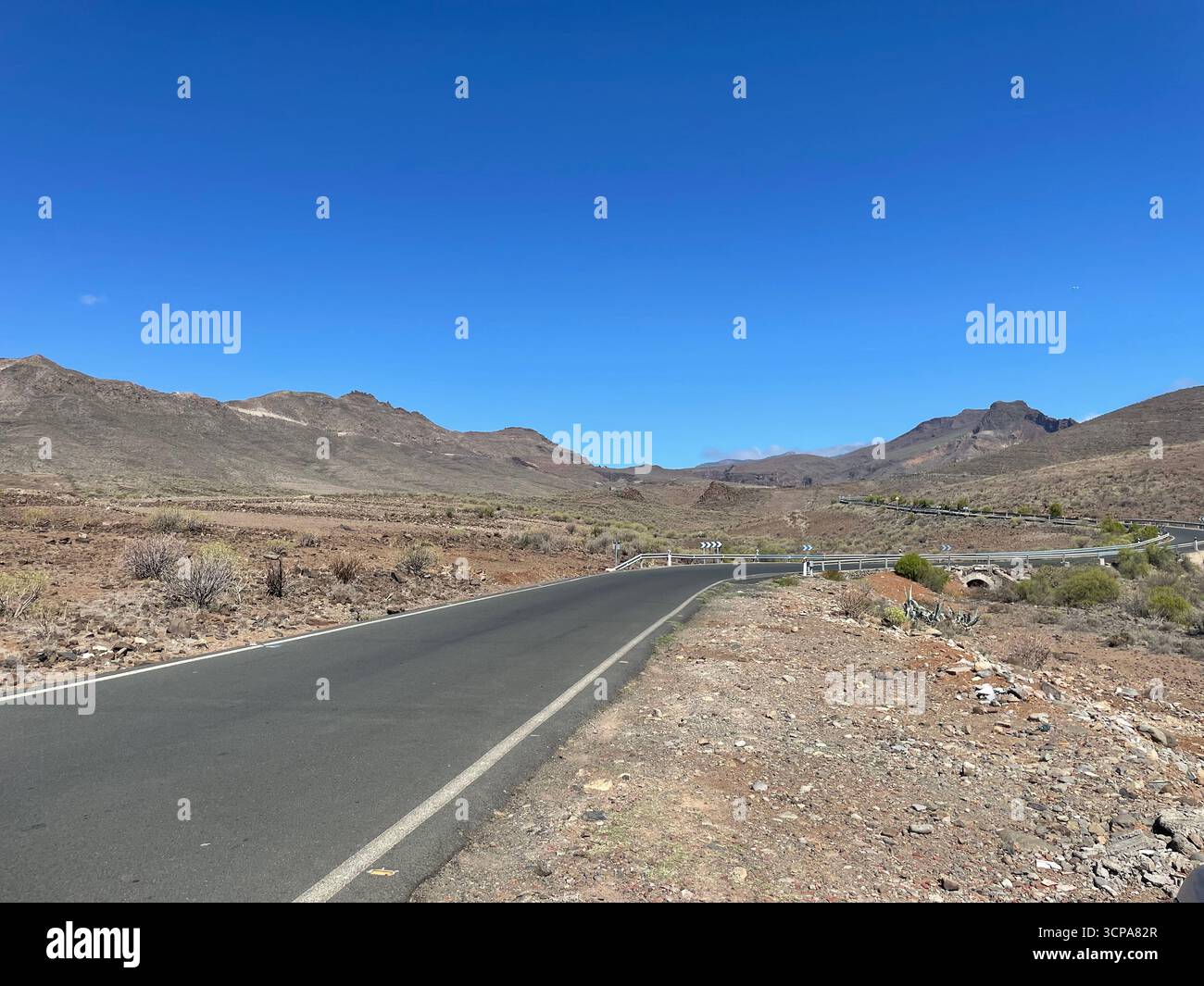 Twisting mountain road with summer blue sky in Gran Canaria - Smartphone Captured Stock Image
