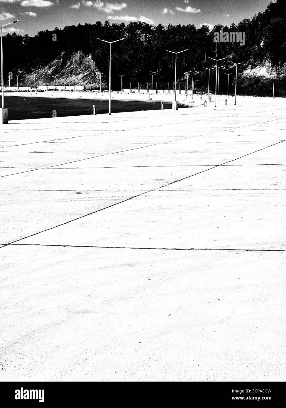 Modern waterfront. Calm body of water with concrete pier and modern street lights. beautiful landscape. black and white photo - Smartphone Captured Stock Image