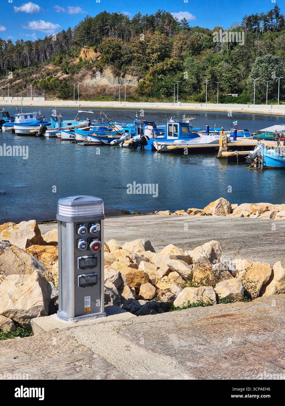 Fishing boats in the harbor. Old port of the city. Calm harbor on a sunny day. Charging station. - Smartphone Captured Stock Image