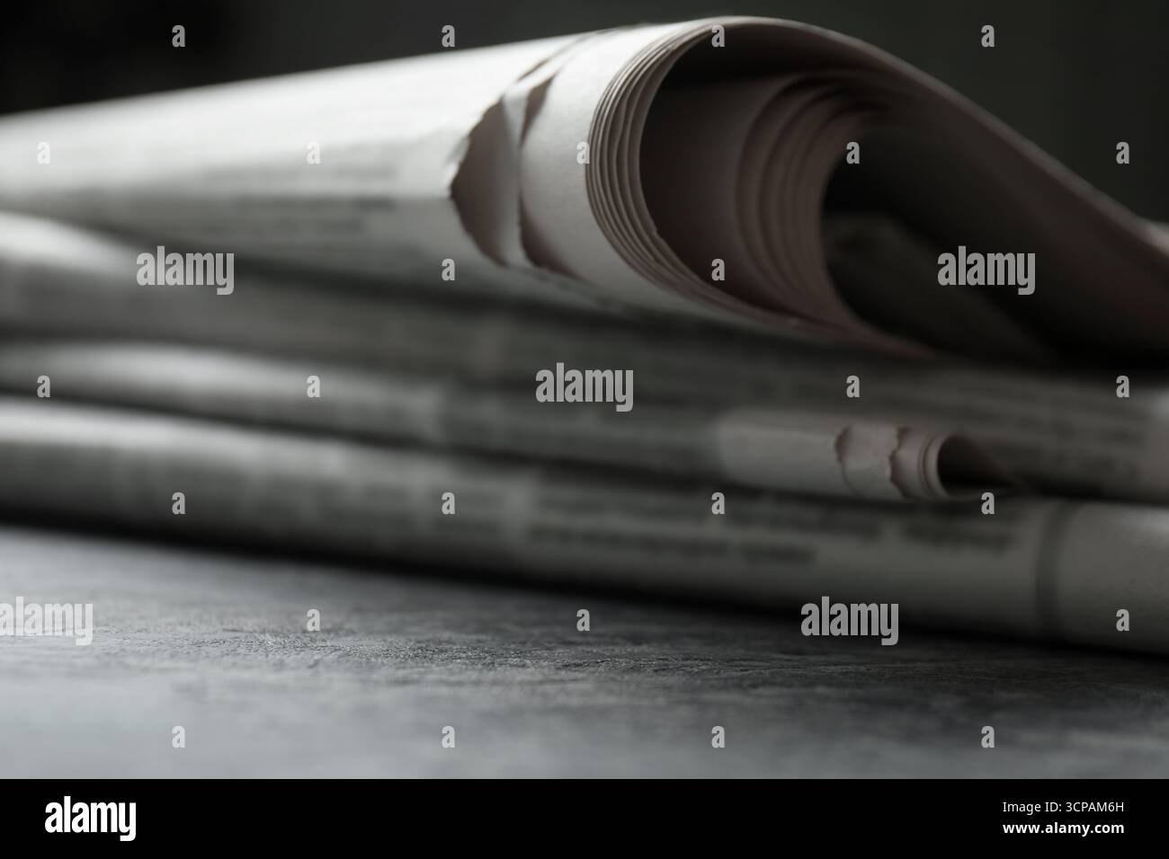 Stack of newspapers on grey table, closeup Stock Photo