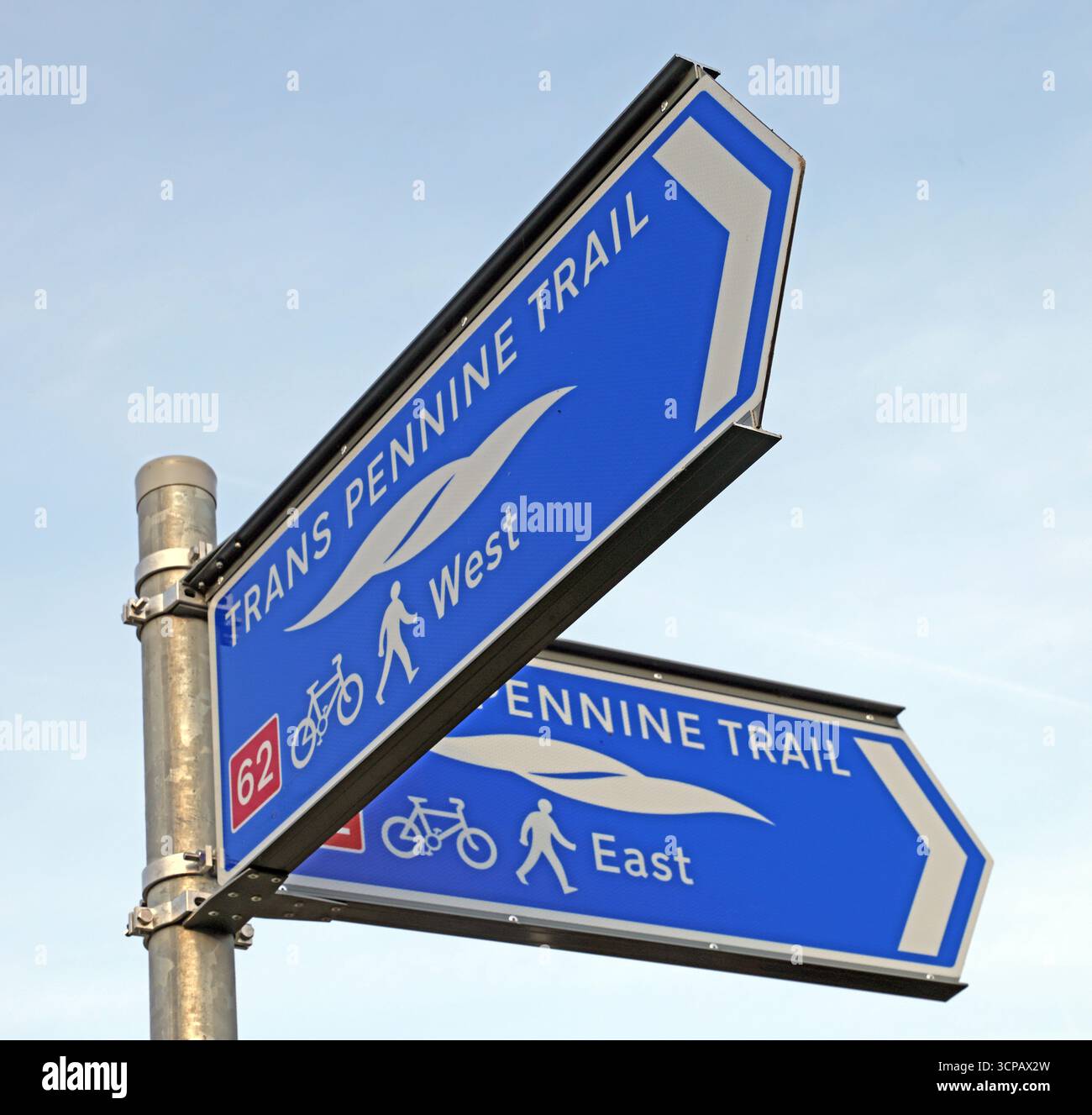 Directional sign for the Trans Pennine Trail indicating west and east routes for walkers and cyclists in the Latchford area of south Warrington. Stock Photo