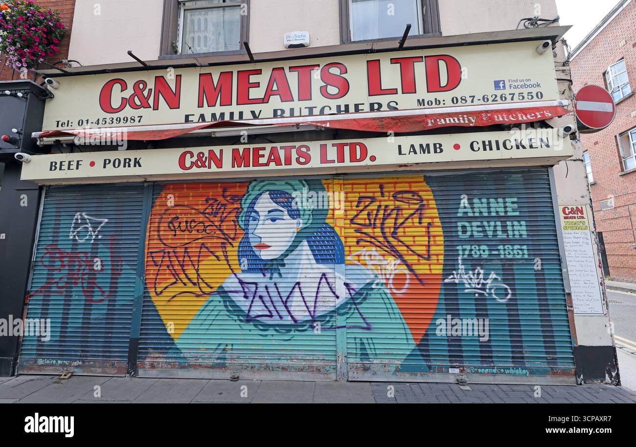 Closed independent Irish butcher shop in Dublin D08 with graffiti mural painted across the metal roller shutter Stock Photo