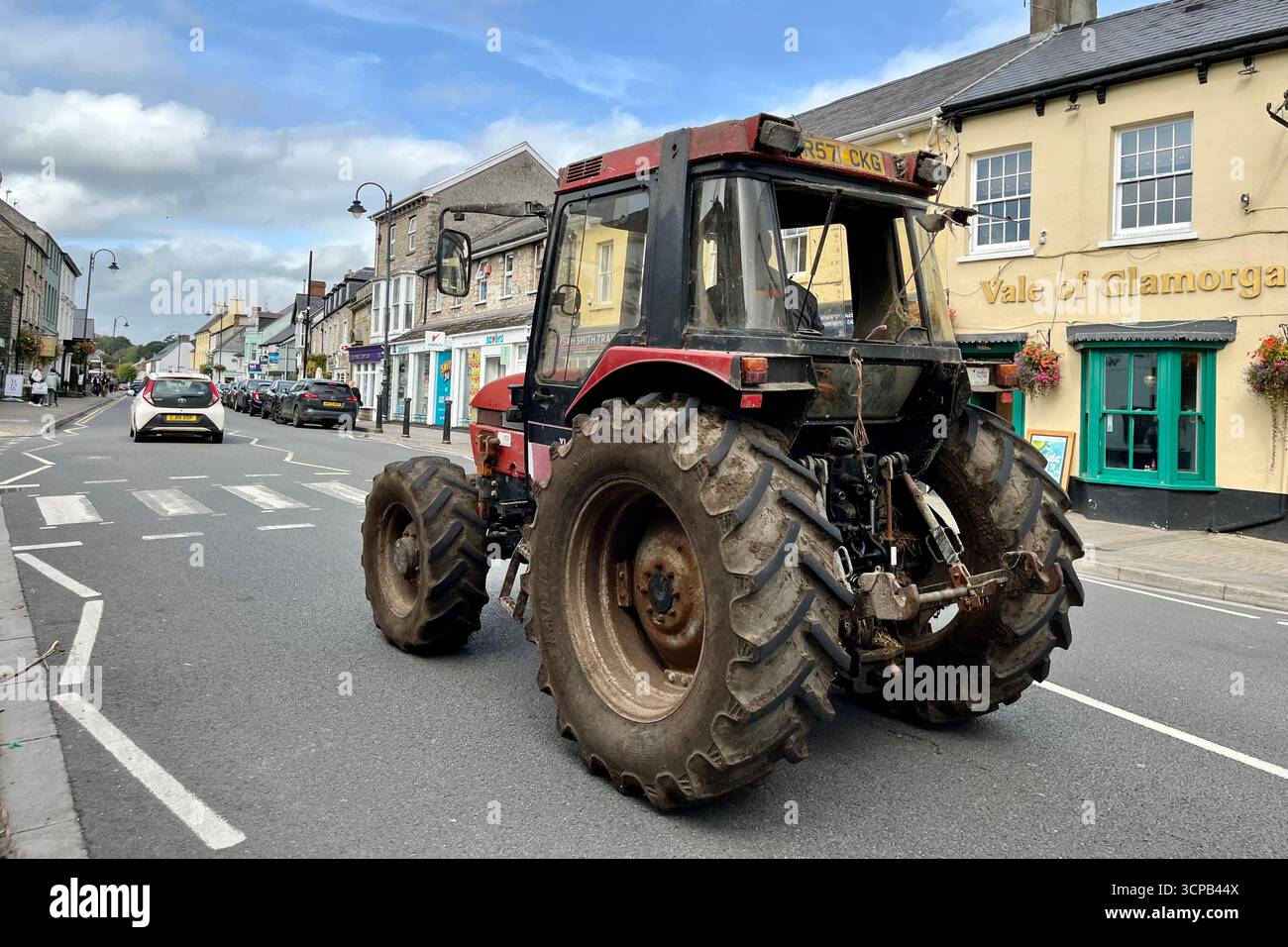 An old Tractor driving through Cowbridge Town Centre. Cowbridge, Vale of Glamorgan, Wales, United Kingdom. 19th September 2025. - Smartphone Captured Stock Image