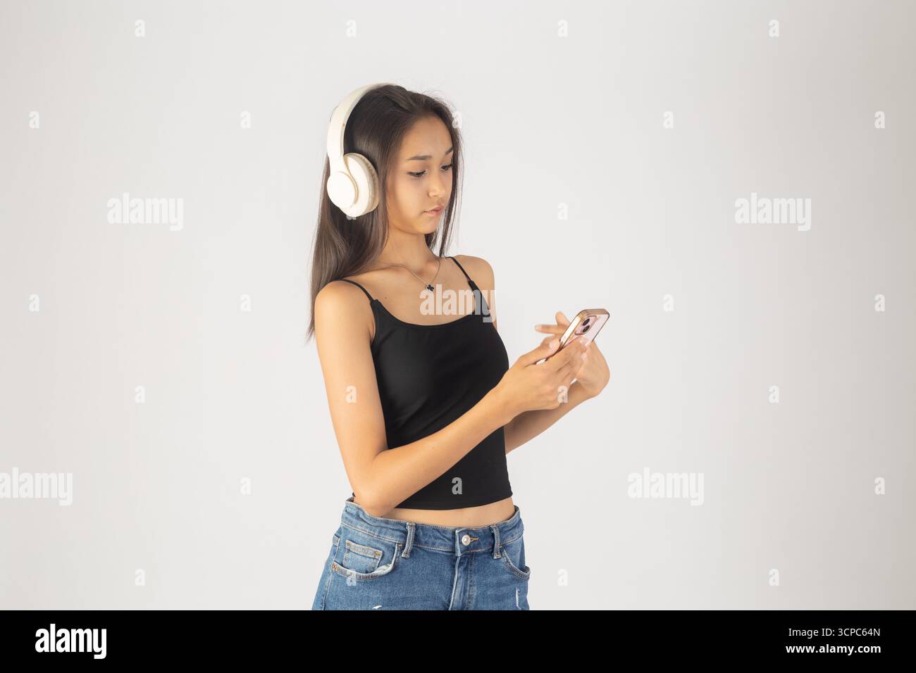 Woman in headphones looks at phone Stock Photo