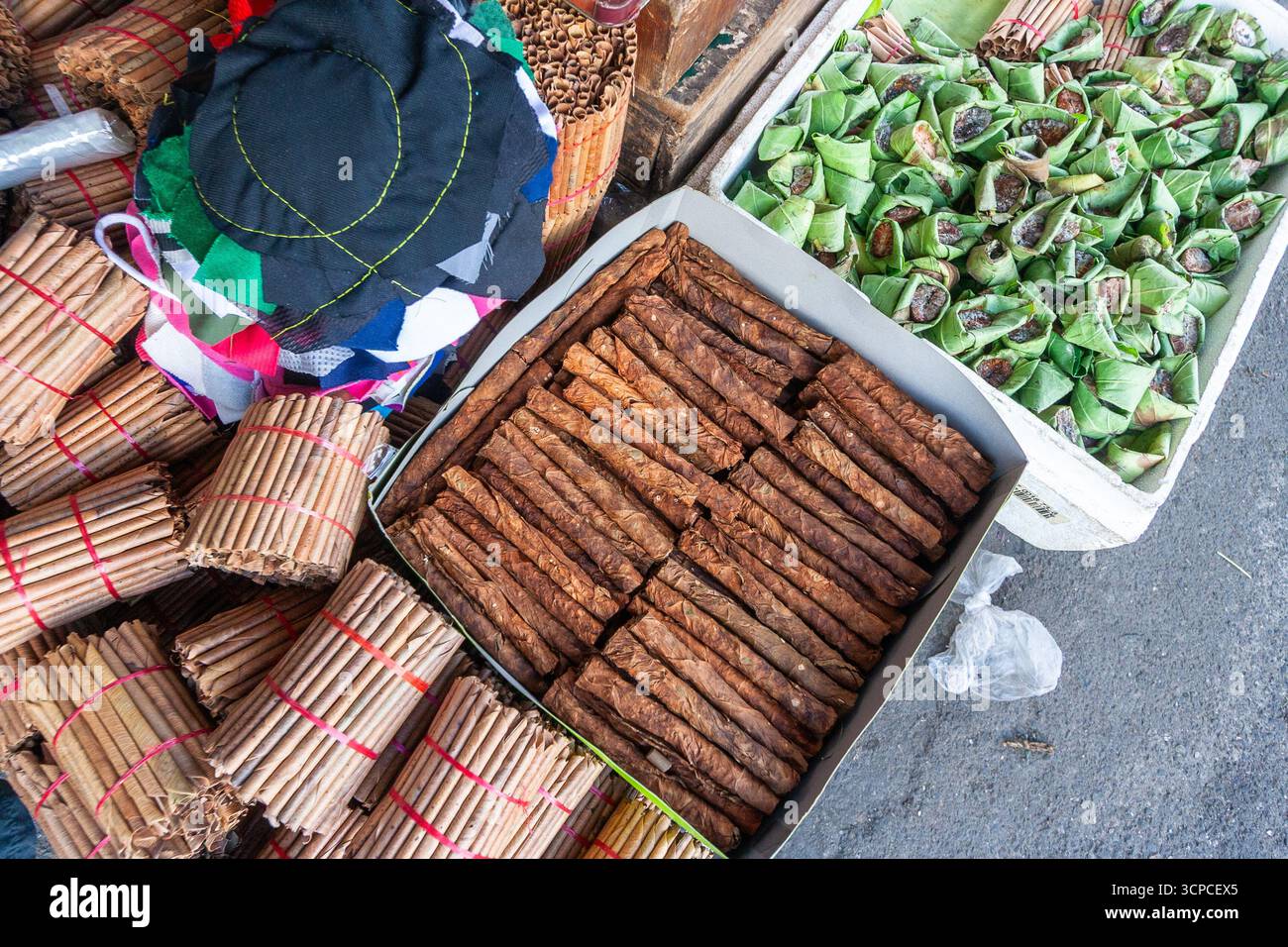 Rolled tobacco and java plum leaves for smoking and areca nut, betel leaf  and lime powder for betel nut chewing sold at a market in Cebu, Philippines  Stock Photo