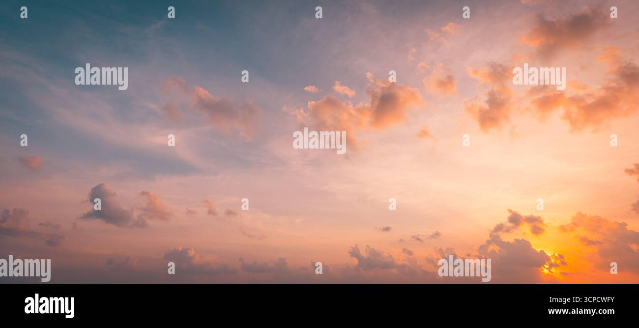 Breathtaking panoramic sunset beach landscape, calm ocean water with gentle waves, vibrant serene sky and clouds, tranquil summer seaside scenery view Stock Photo