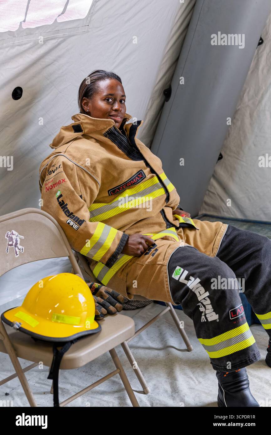 Black female firefighter in her turnout gear, resting in a tent in Montgomery Alabama, USA. Stock Photo