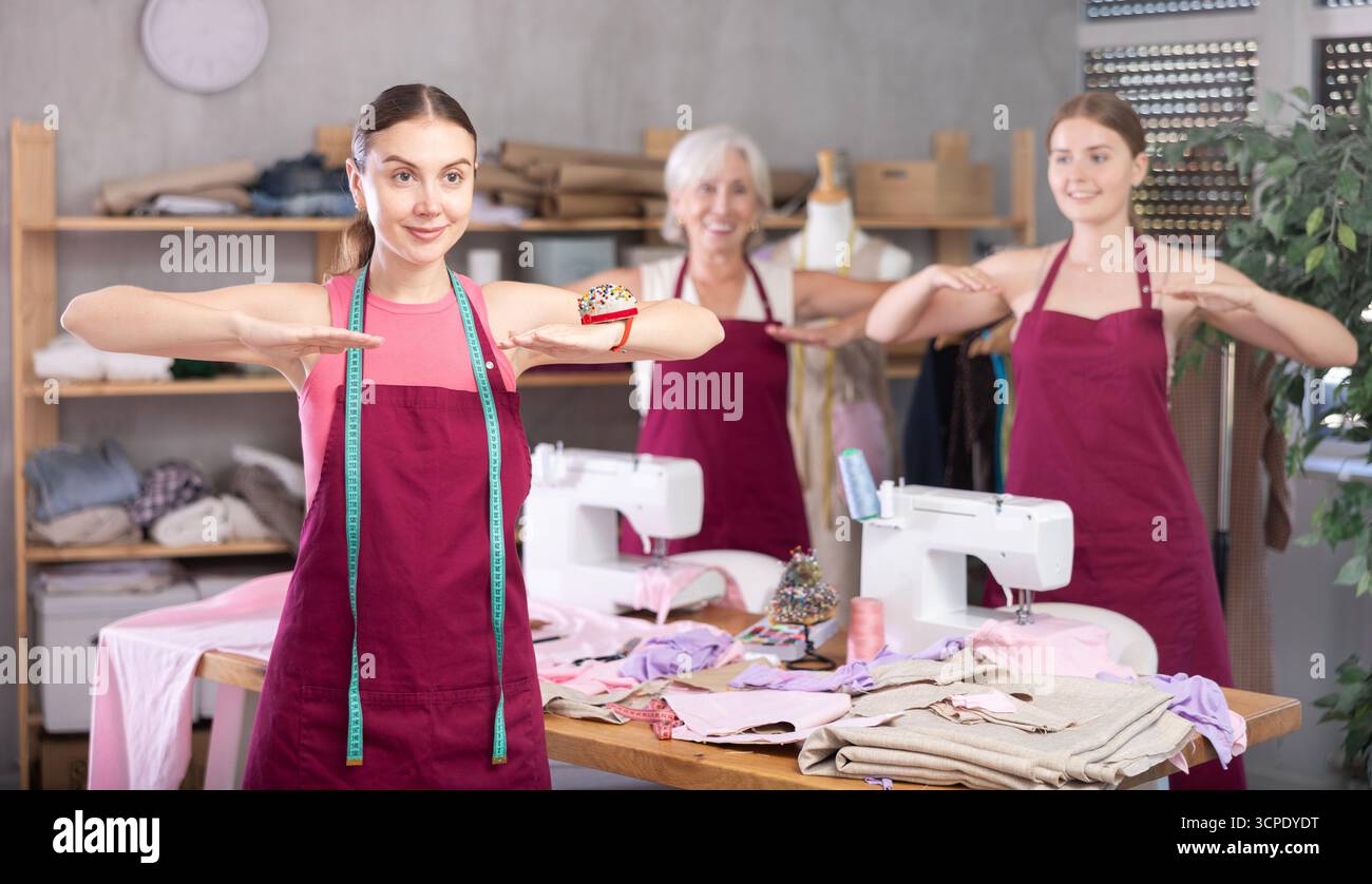 team of dressmakers doing a warm-up in the workshop Stock Photo