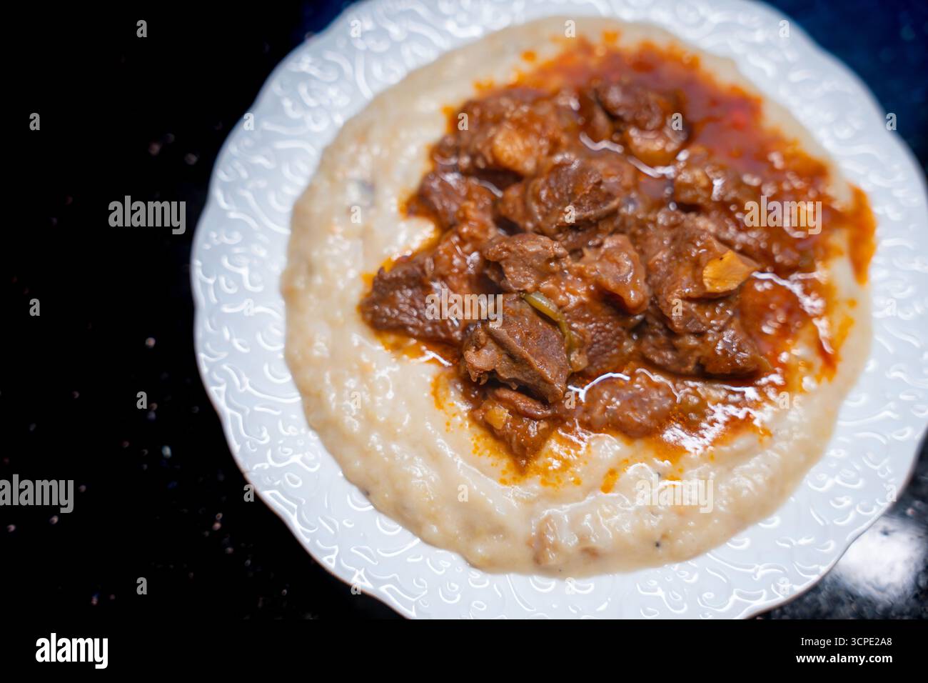 Traditional Turkish Hunkar Begendi food with creamy eggplant puree base. Made with tender meat served on white plate. Turkish anatolia cuisine concept Stock Photo