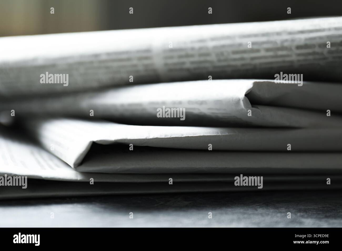 Stack of newspapers on grey table, closeup Stock Photo