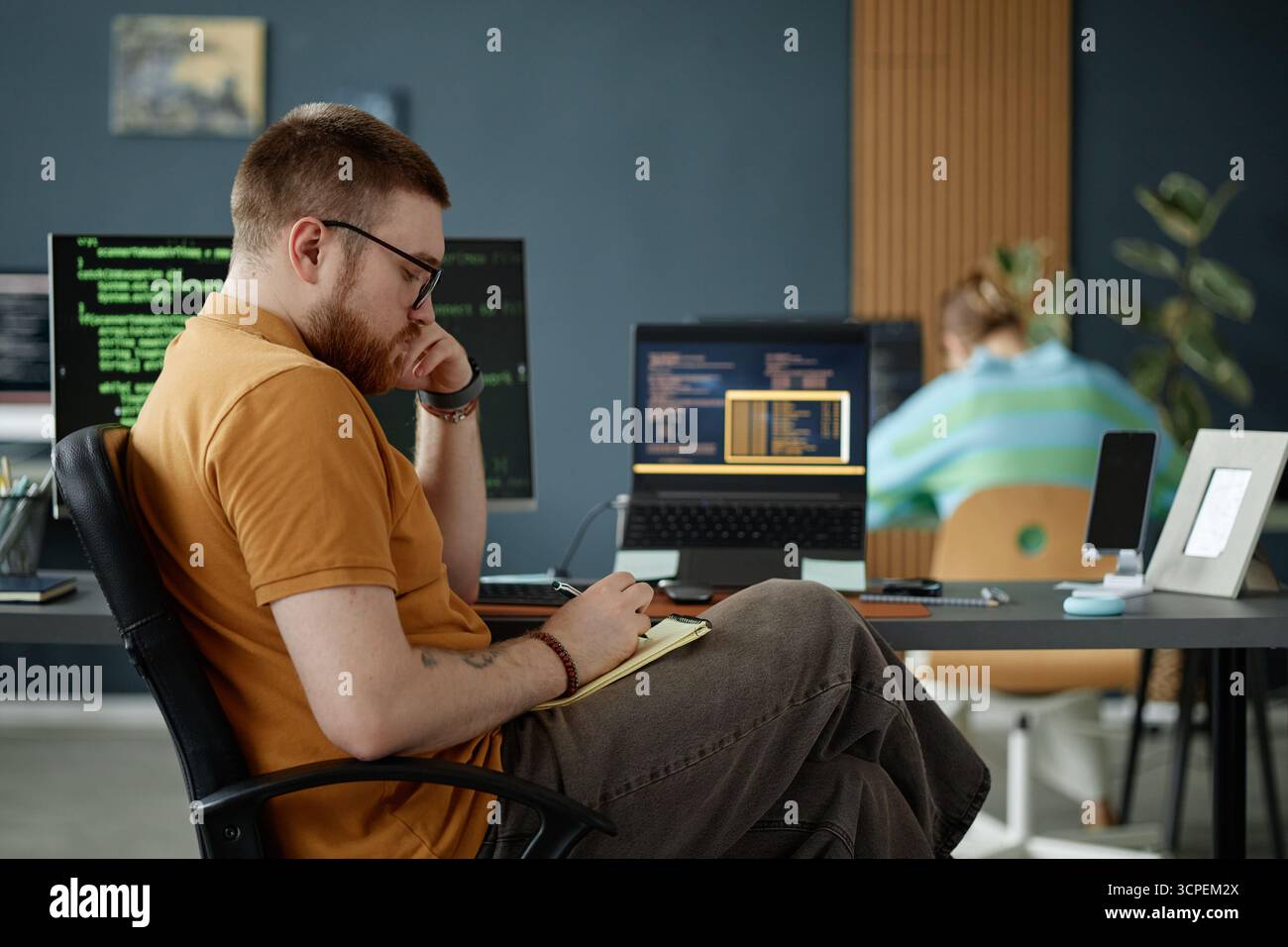 Young Adult Man Working on Software Development in Modern Office Stock Photo