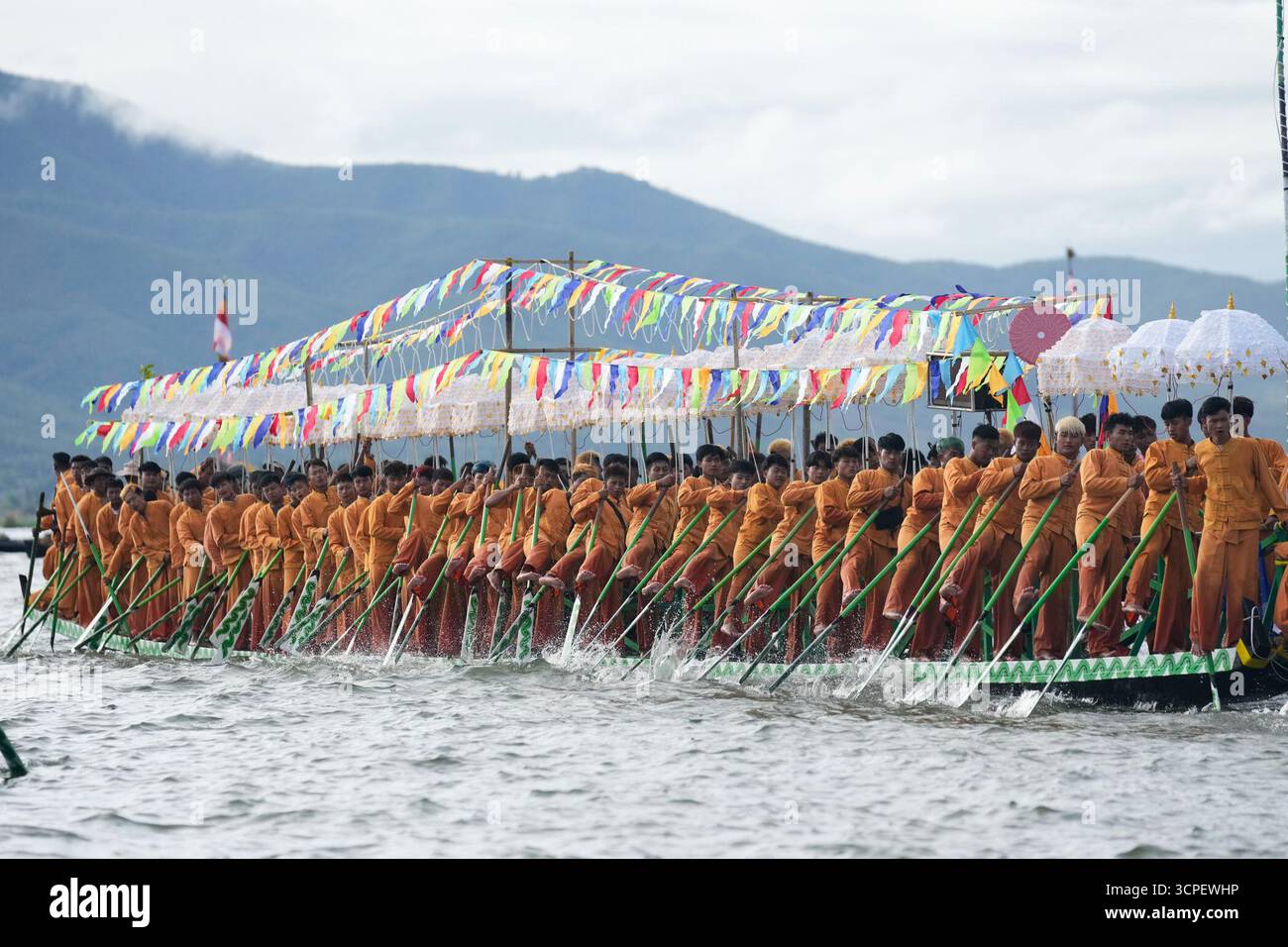 Intha ethnic people row on a long boat in a procession carrying Buddha ...