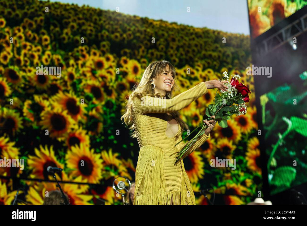 Margo Price gives flowers to fans during the Farm Aid 40 Music Festival ...