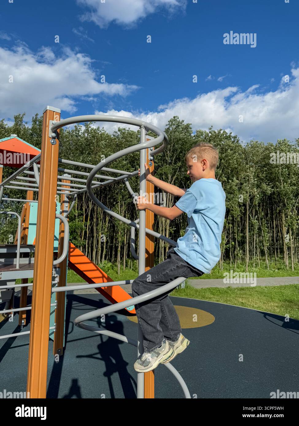 Teen boy working out on pull-up bars at an outdoor sports playground during a bright summer day, fitness and activity concept - Smartphone Captured Stock Image