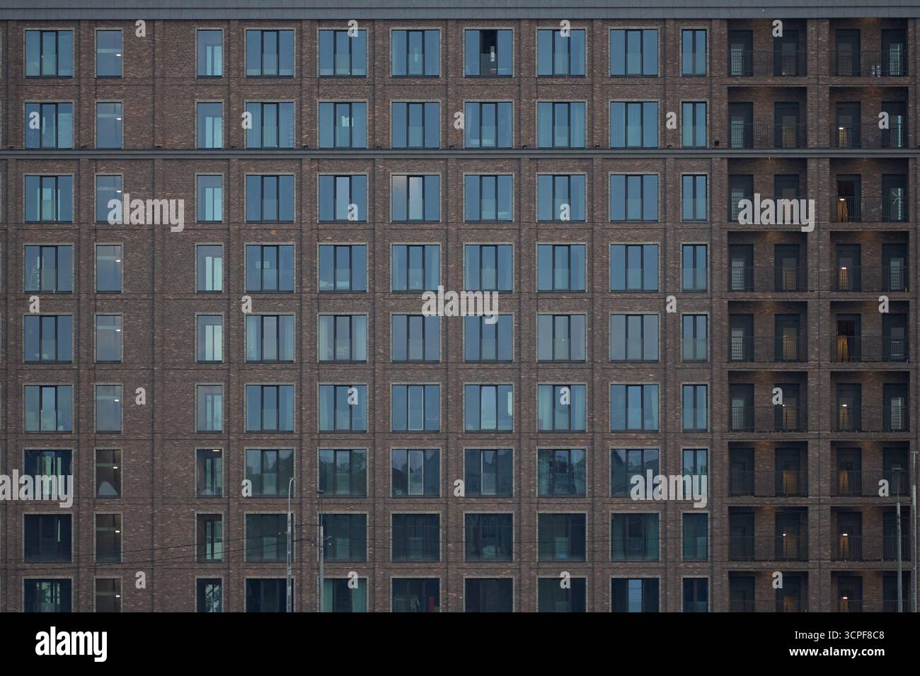 Modern apartment building facade featuring multiple rows of identical ...