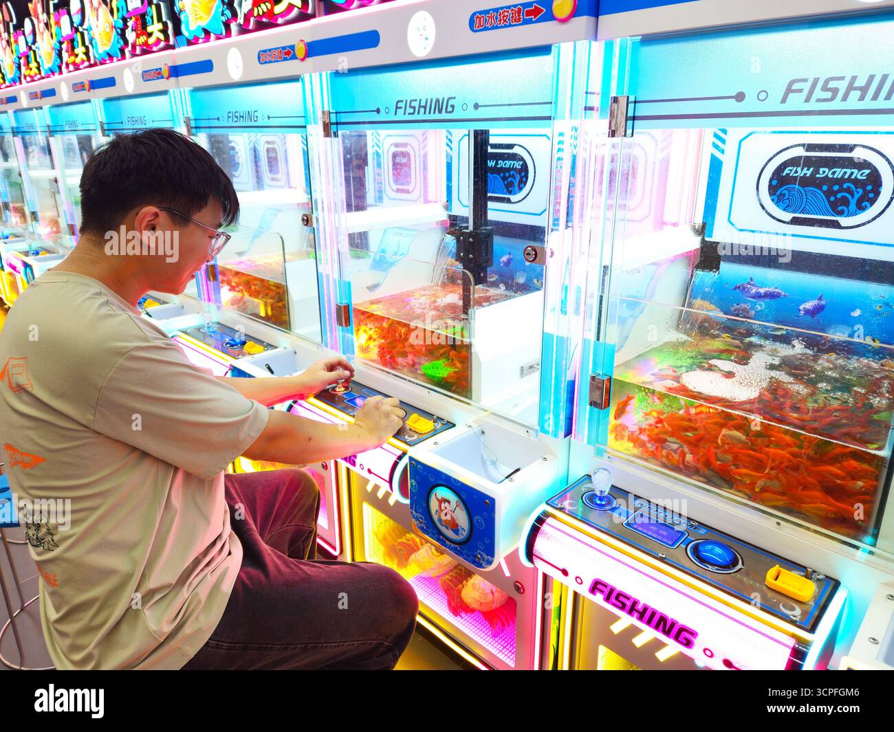 Man Playing Fishing Arcade Machine with Live Fish in Shopping Mall ...