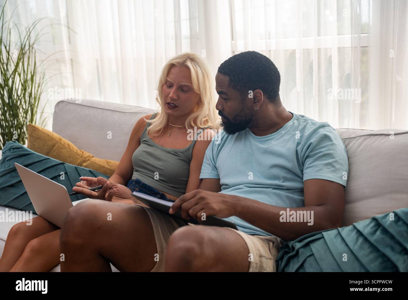 Young couple, freelancer businessman and businesswoman, working at home on laptop computer, testing new innovative technology and online internet tool Stock Photo