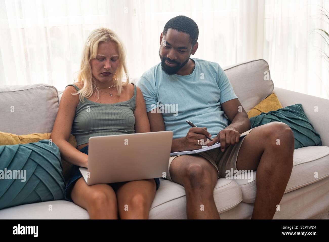 Young couple, freelancer businessman and businesswoman, working at home on laptop computer, testing new innovative technology and online internet tool Stock Photo