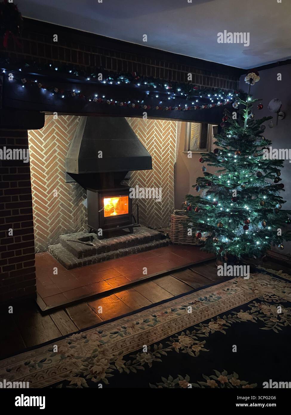 Log burning stove at christmas time with tree and lights - Smartphone Captured Stock Image