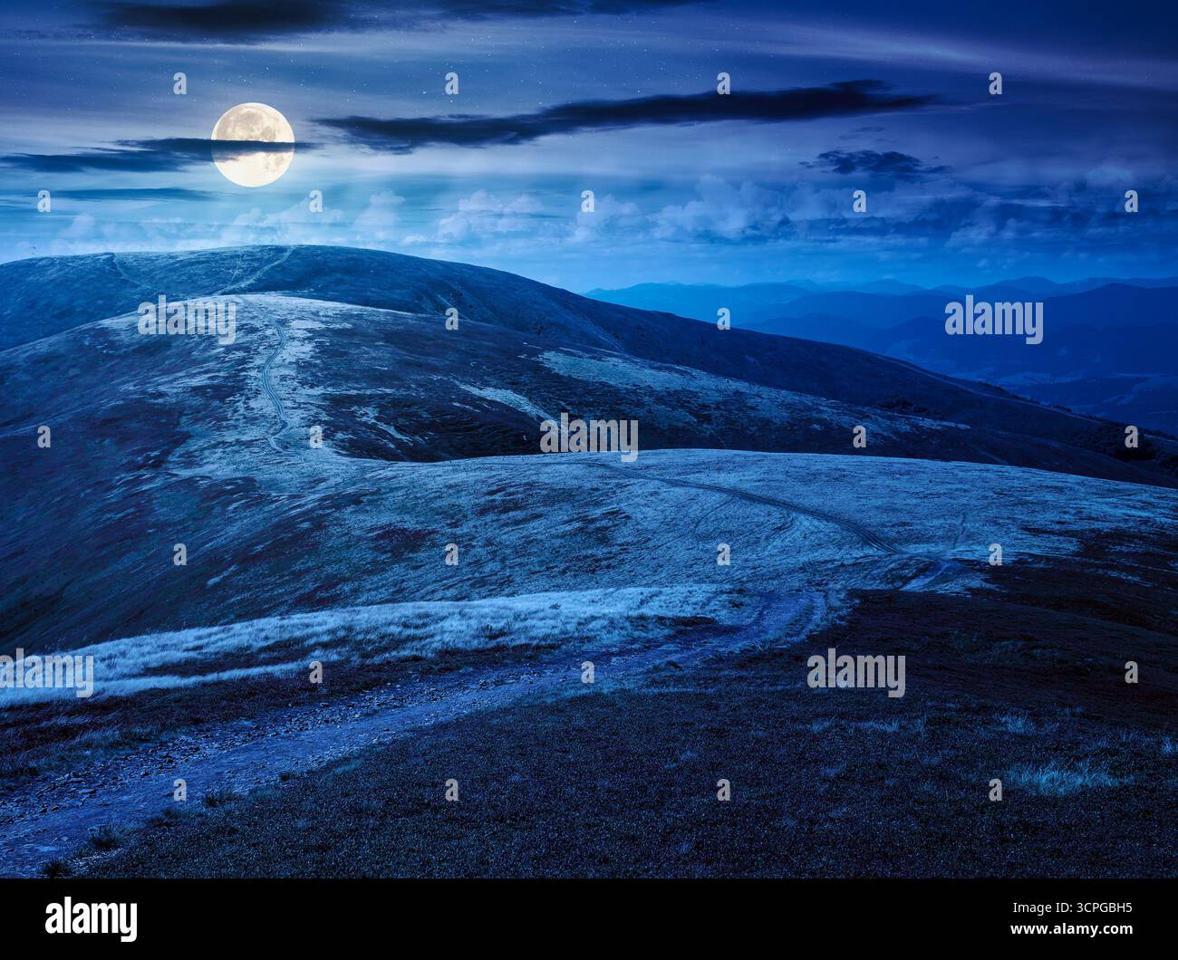 scenery mountain ridge in late summer at night. outdoor adventure. alpine landscape of mountain range in full moon light. grassy meadows and rolling h Stock Photo